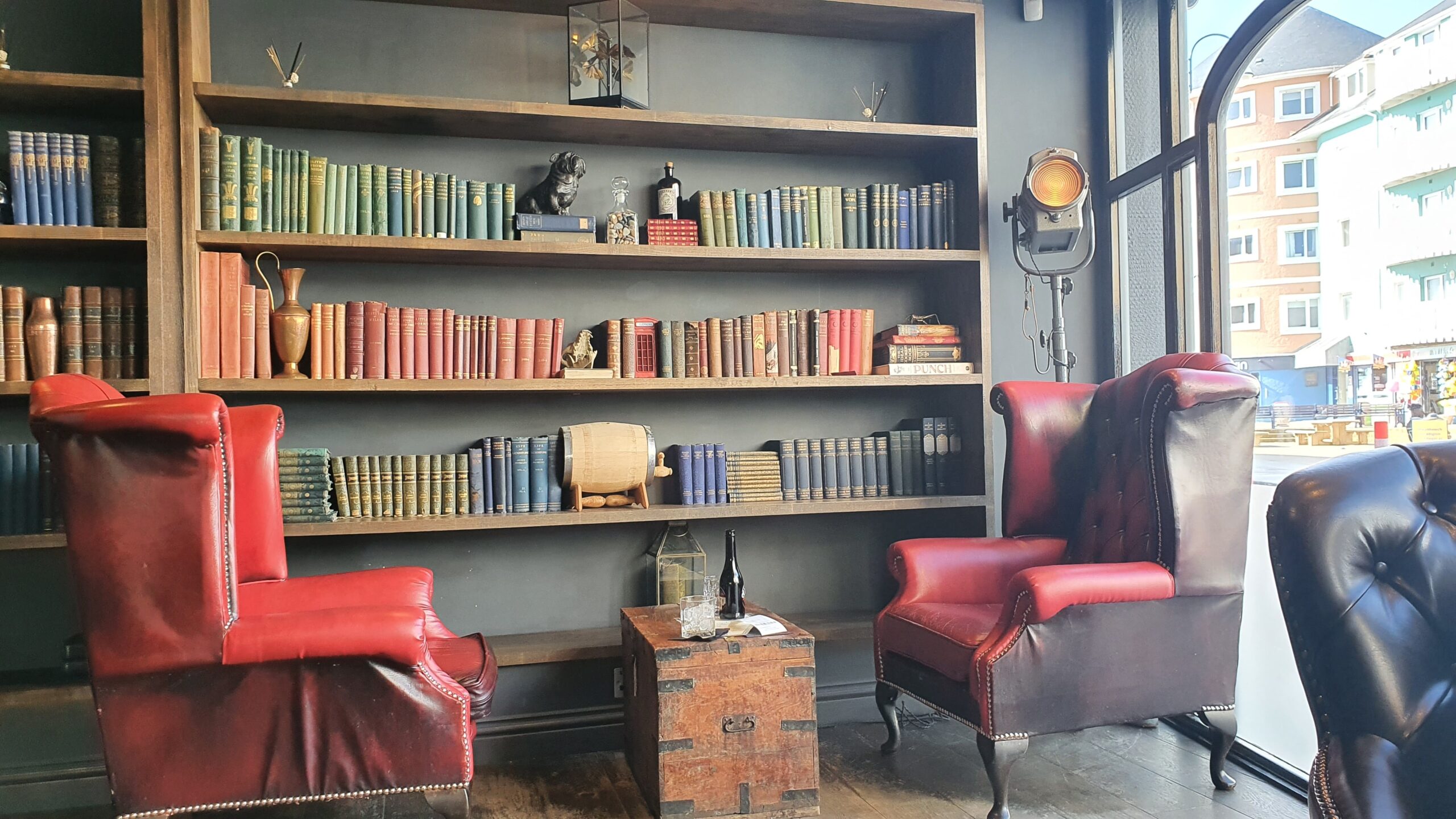 Bookcase full of personal development books for mindful travelers, including The Alchemist, The Power of Now, The Courage to Be Disliked, The Silva Mind Control Method, and Atomic Habits.